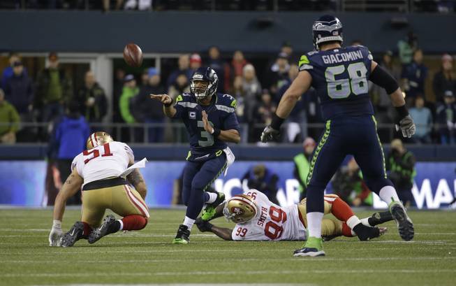 Seattle Seahawks' Russell Wilson throws the ball against the San Francisco 49ers  during the first half of the NFL football NFC Championship game Sunday, Jan. 19, 2014, in Seattle. (AP Photo/Ted S. Warren)